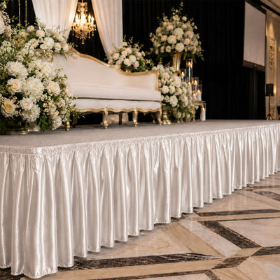Elegant wedding stage with white floral arrangements and gold sofa backdrop