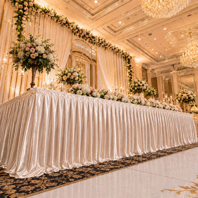 Elegant wedding reception stage with floral decor and chandeliers