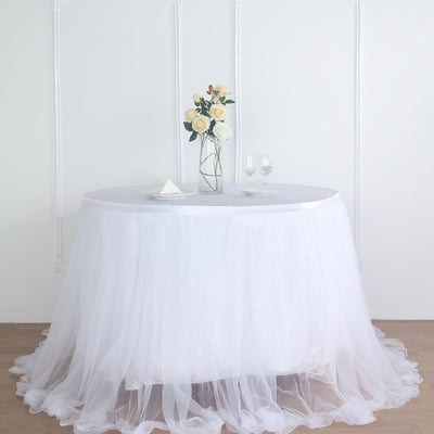 Round table with white tulle skirt and floral centerpiece.