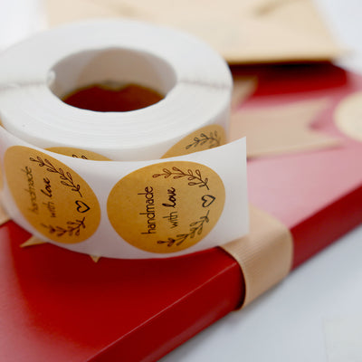 Roll of handmade with love stickers on a gift box.