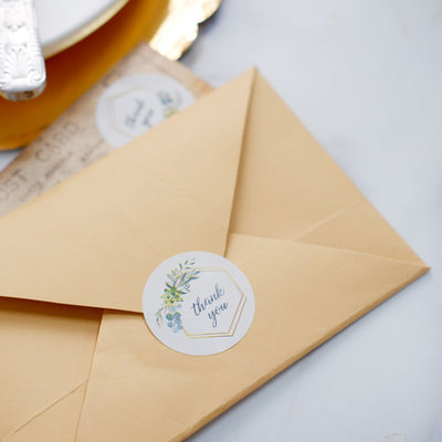 Thank you sticker on an envelope with a vintage postcard background.