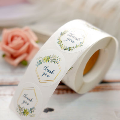 Thank you stickers on a roll with floral design and hexagon shape.