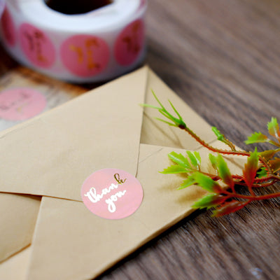 Thank you sticker on an envelope with greenery accent.
