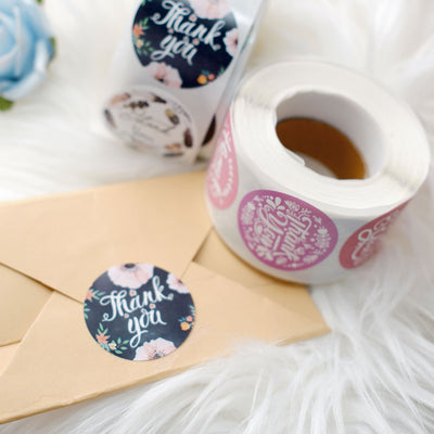 Colorful thank you stickers on a roll with an envelope.