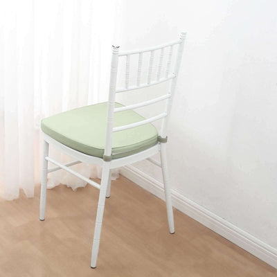 White chair with green cushion against a light background.