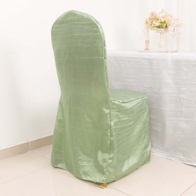 Green satin chair cover draped on a chair in a decorated room.