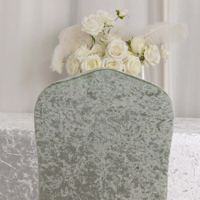 Green velvet dining chair with soft texture, adorned with white roses behind it.