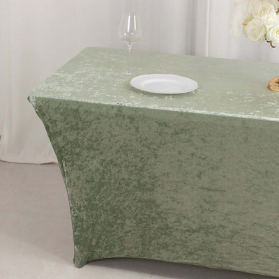 Elegant green tablecloth with a plate and glass on a table.
