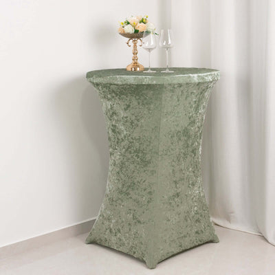 Green textured table cover with floral centerpiece and glasses.