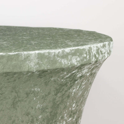 Green velvet side table with a unique sculptural design.