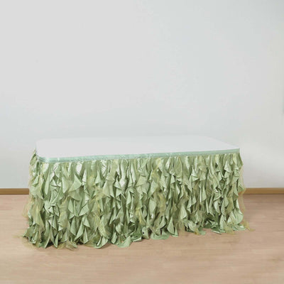 Green ruffled table skirt draped over a white table against a plain background.
