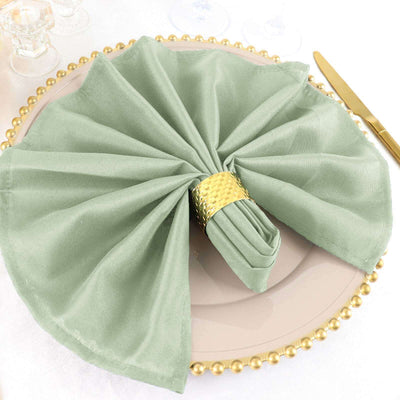 Elegant green napkin arranged on a gold-rimmed plate.