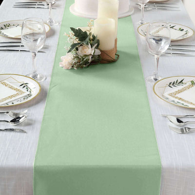 Mint green table runner on a beautifully set dining table with elegant plates and candles.