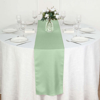 Green table runner on a round table set for a formal dining experience.