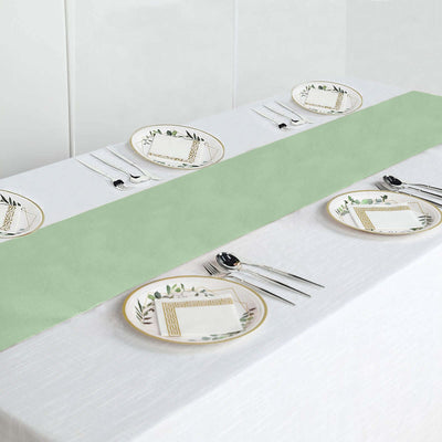 Table setting with green runner and decorative plates on a white tablecloth.