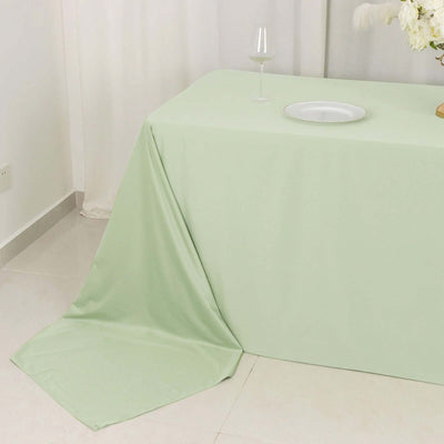 Green tablecloth draped elegantly on a table with a glass and plate