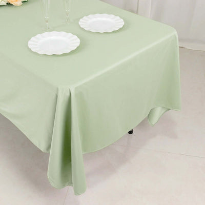 Green tablecloth draped over a table with white plates