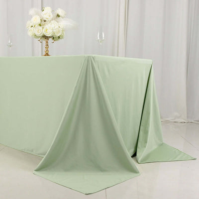 Green tablecloth draped elegantly over a table with floral centerpiece.