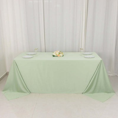 Mint green tablecloth draped elegantly over a table with floral centerpiece.