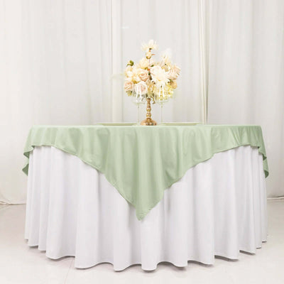 Elegant table setting with green and white linens and floral centerpiece.