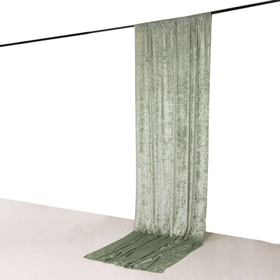 Green velvet curtain draped elegantly on a rod, showcasing its full shape.