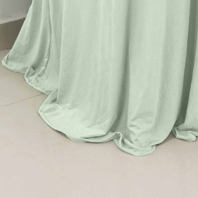 Soft mint green fabric draped elegantly on a smooth surface.