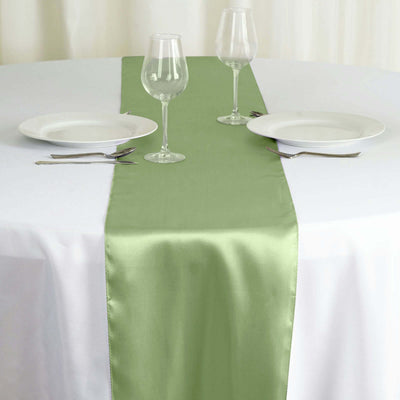 Green table runner on a white tablecloth with plates and glasses.