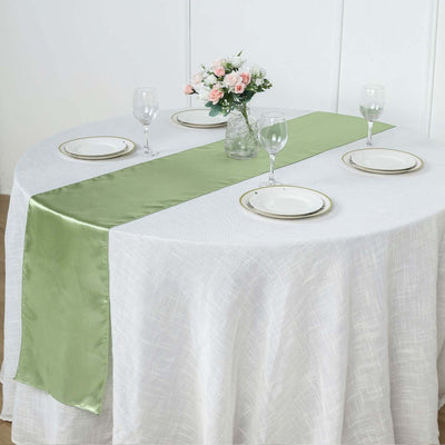 Green satin table runner on a decorated dining table with plates and glasses.