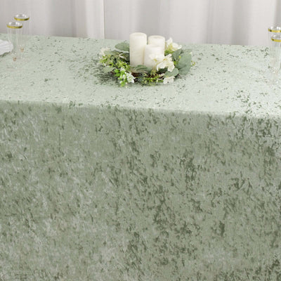 Green textured tablecloth with a floral centerpiece and candles.