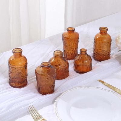 Set of six vintage amber glass bottles on a table.