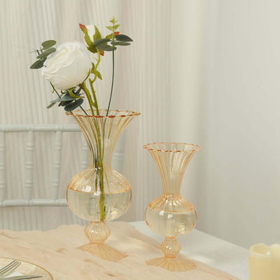 Elegant transparent vases with flowers on a soft tablecloth.