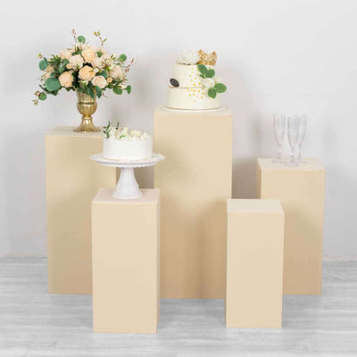 Decorative cake display with flowers and elegant table settings in a studio setup.
