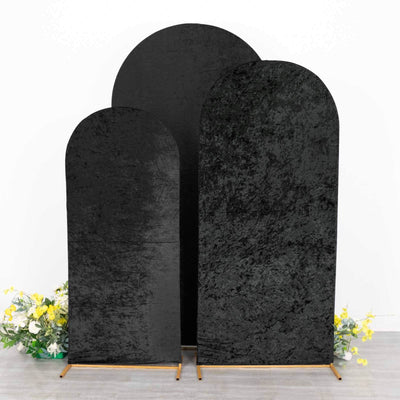 Set of three black velvet backdrops on wooden stands with floral accents.