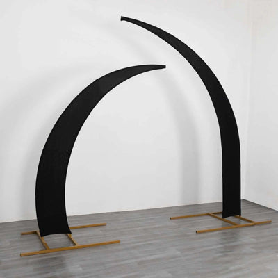 Black curved display stands on a wooden base against a plain backdrop.