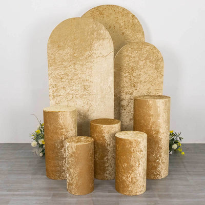 Gold velvet display pedestals in various shapes and sizes on white backdrop