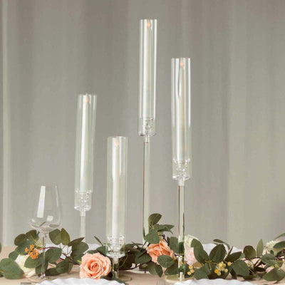 Elegant glass candle holders with candles and floral arrangement.