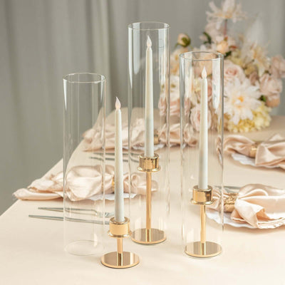 Elegant candle holders with clear glass and gold accents, perfect for table decor.