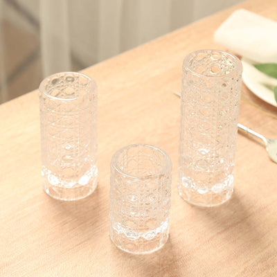 Set of three elegant clear glass vases on a wooden table.