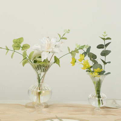 Elegant floral arrangements in glass vases on a neutral table setting.