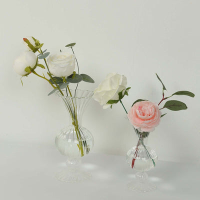 Crystal vases with white and pink roses, elegantly displayed.