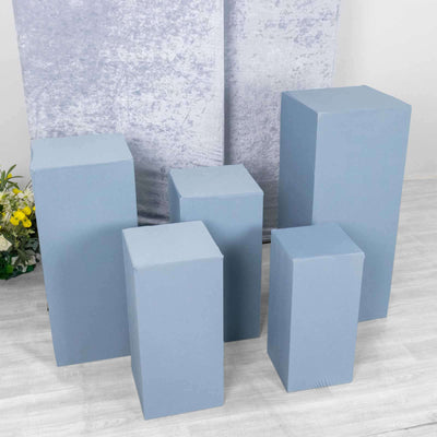 Blue display risers in various heights on a plain backdrop.