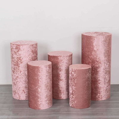 Set of five pink velvet display pedestals in various heights.