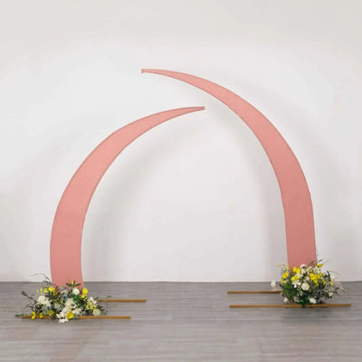 Pink arch with floral arrangements on a plain backdrop.