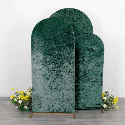 Three green velvet backdrops with floral arrangement at the base.