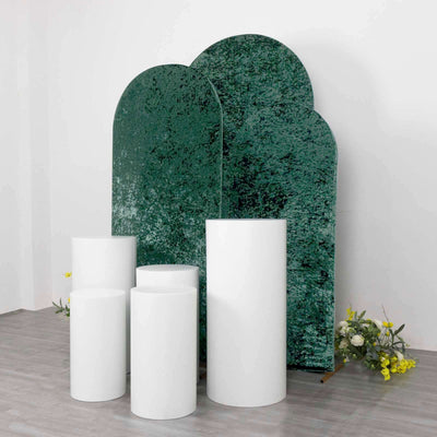 Green textured backdrop with white pedestals in a minimalist setting.