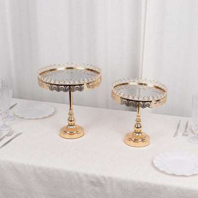 Elegant gold cake stands on a dining table with white plates and glassware.
