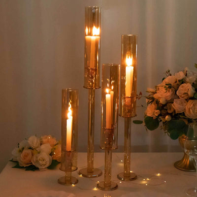 Elegant glass candle holders with lit candles, surrounded by soft floral decor.