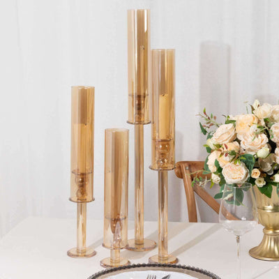 Set of five amber glass candle holders in varying heights.