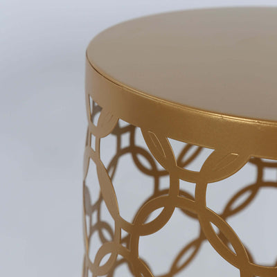Gold metal accent table with decorative cut-out design.