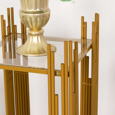 Gold metal accent table with clear glass top and unique vertical design.